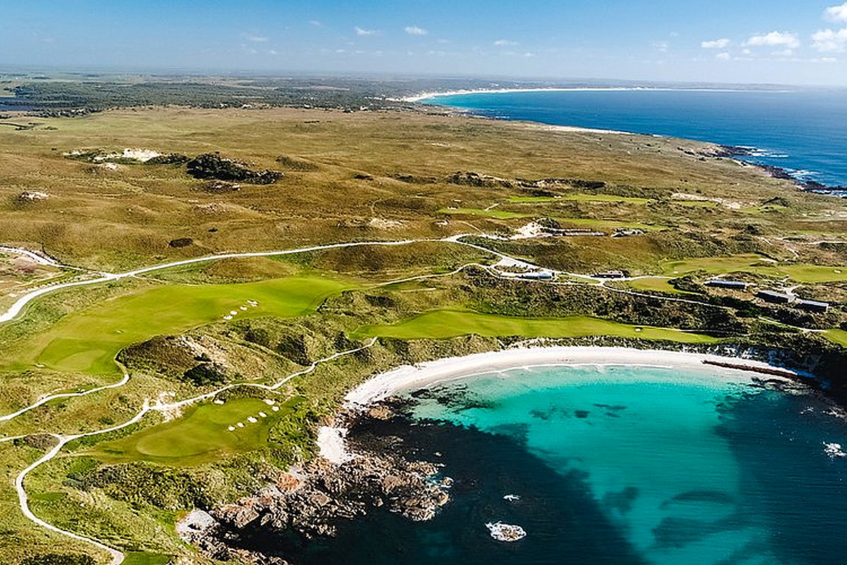 Aerial view of coastal Barnbougle Dunes golf course beside turquoise bay
