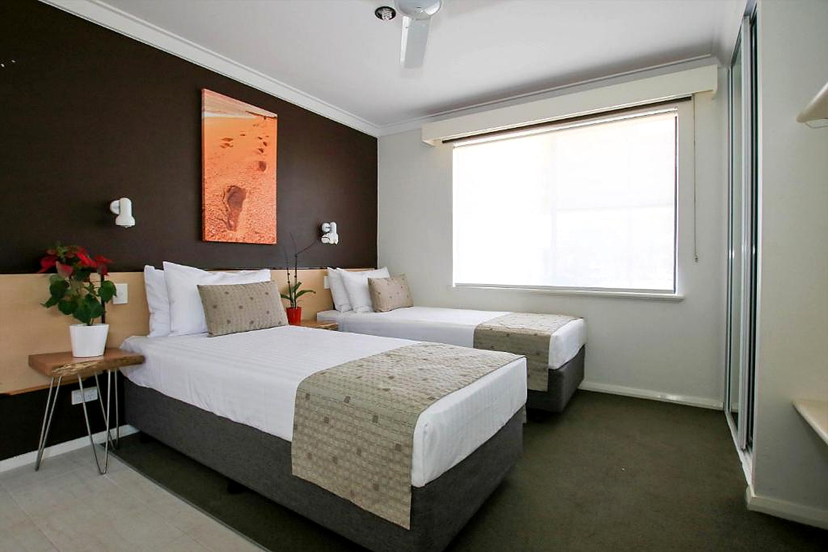 Modern twin hotel room with dark feature wall