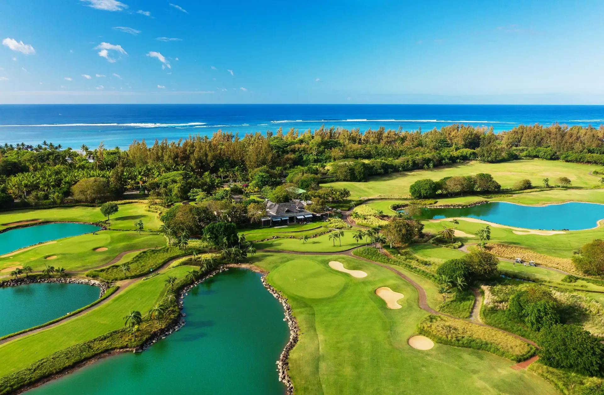 Aerial view of tropical Le Château Golf Course - Mauritius beside turquoise ocean