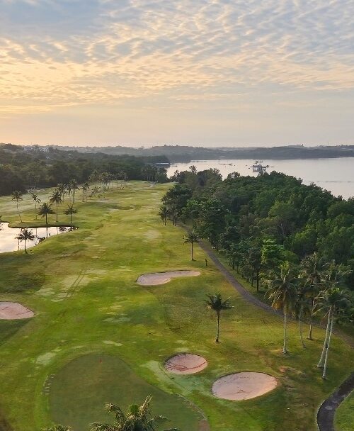 Aerial view of tropical atam Island Country Club beside calm river at sunset