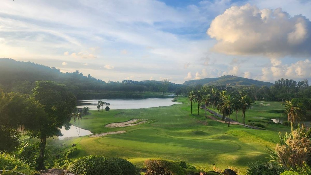 Lush tropical Blue Canyon Country Club, Lakes Course with lake and mountain backdrop