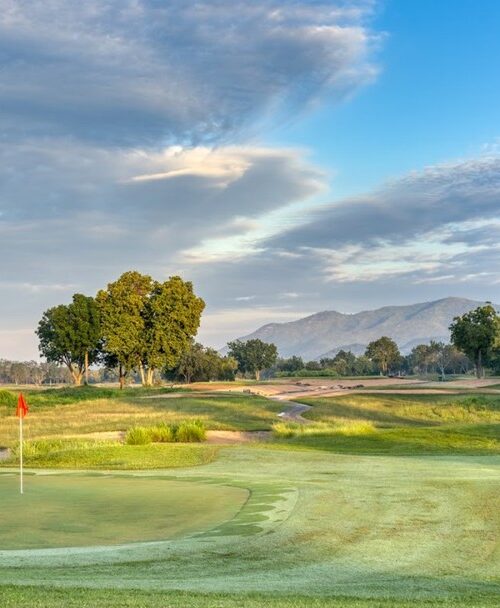 Scenic Lake View Resort & Golf Club green with red flag and mountain backdrop