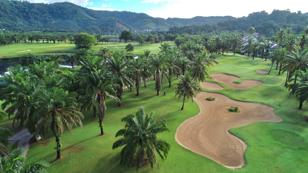Aerial view of tropical Loch Palm Golf Club with sand bunkers and palms