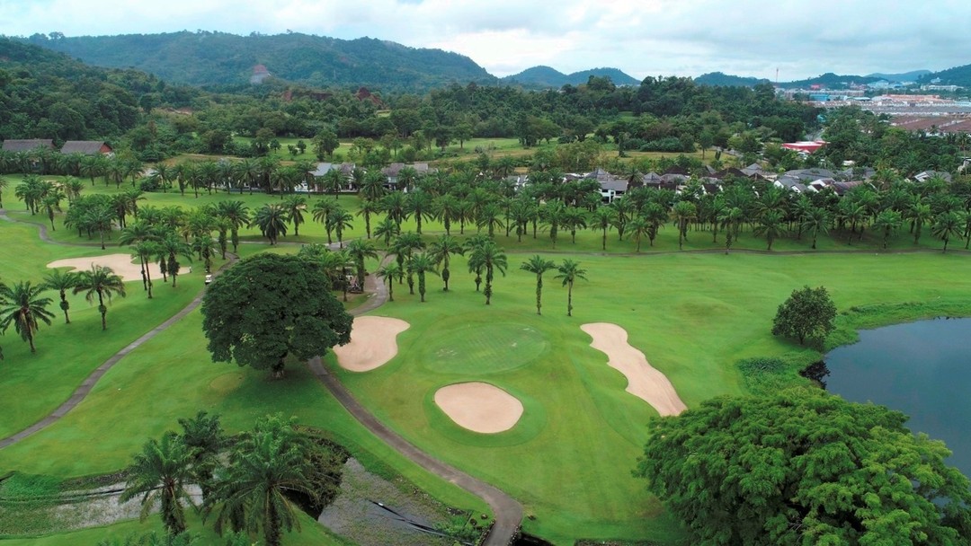 Aerial view of tropical Loch Palm Golf Club with sand bunkers and palms