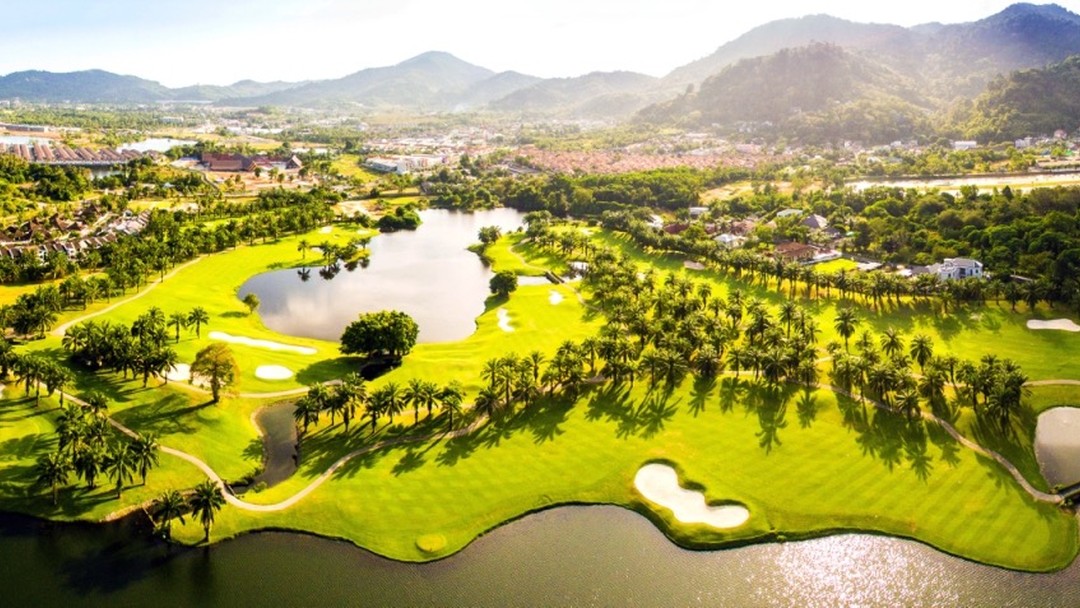 Aerial view of tropical Loch Palm Golf Club with lakes and mountains