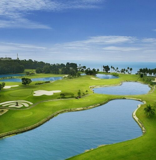 Aerial view of tropical Palm Springs Golf & Country Club with ocean backdrop