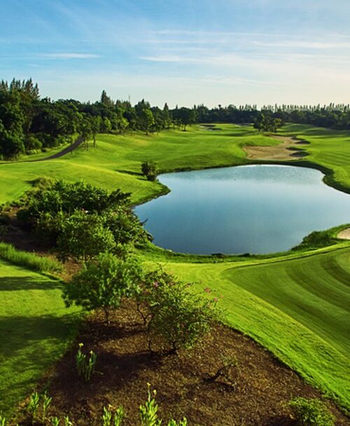 Lush Riverdale Golf Club with serene pond and sand bunker. Play Riverdale Golf Club with Golfing Getaways