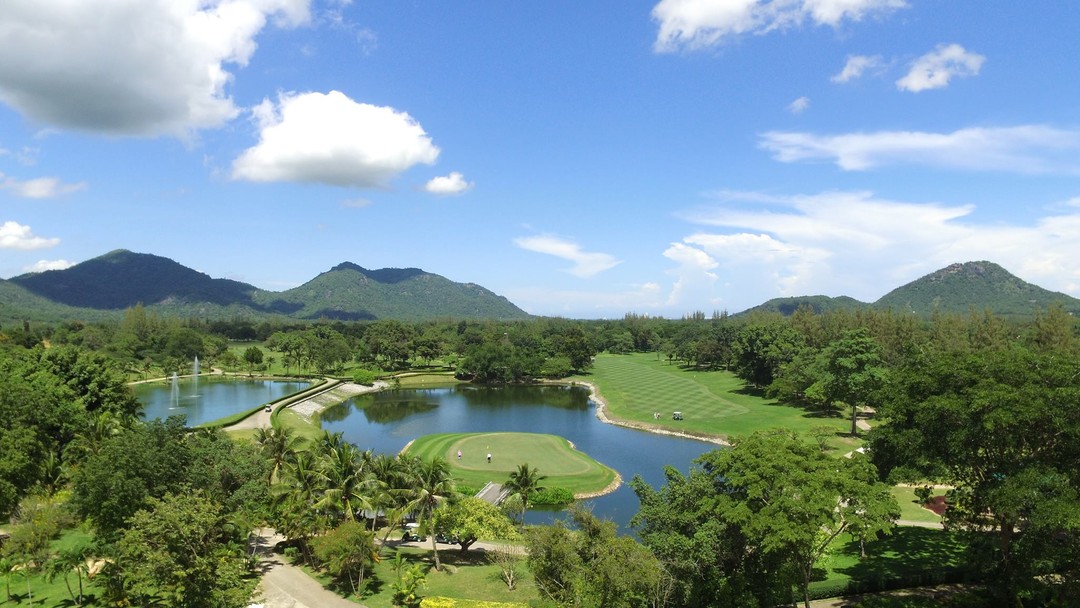 Lush tropical Springfield Royal Country Club with lakes and mountain backdrop