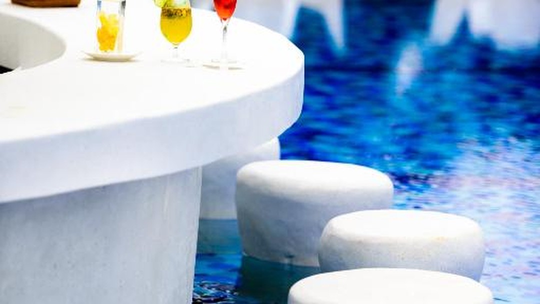 Poolside swim-up bar with colourful cocktails and white stools