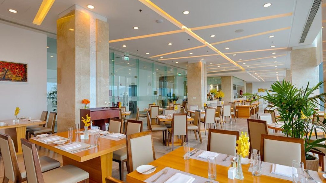 Bright modern hotel restaurant dining room with yellow flowers